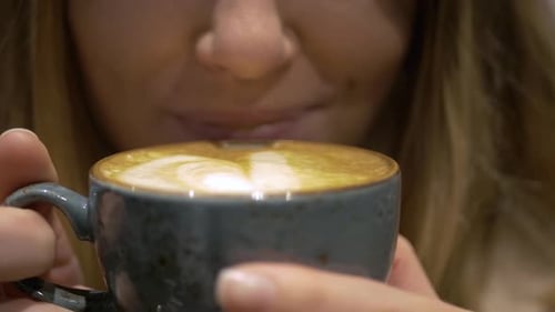 Woman Enjoys Coffee in a Stylish Blue Mug