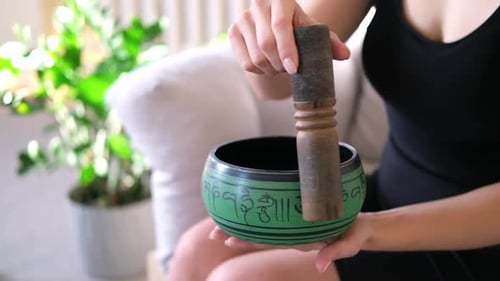 Tibetan Singing Bowl During Meditation Lead Yoga Class Female Hands is Making the Sound and
