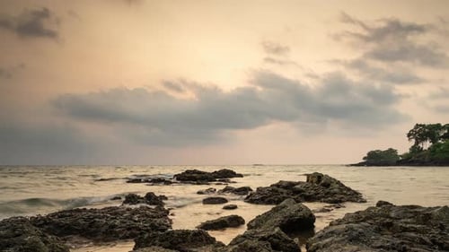 Timelapse of dramatic sunset with orange sky in a cloudy day at a beach.