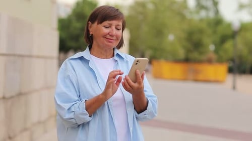 Mature Woman Using Phone in Urban Setting