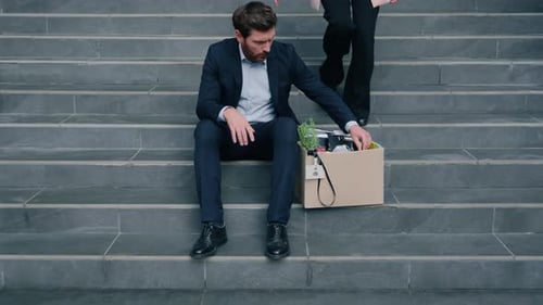 Caucasian Upset Male Man Guy with Dismissal Box Sitting on Stairs Businessman Dismissed From Work