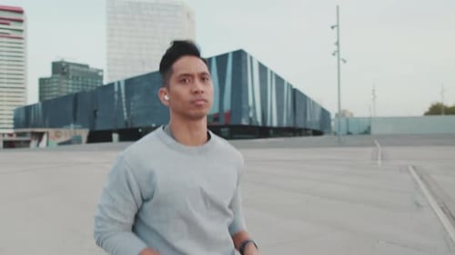 Young man in wireless headphones on a morning run