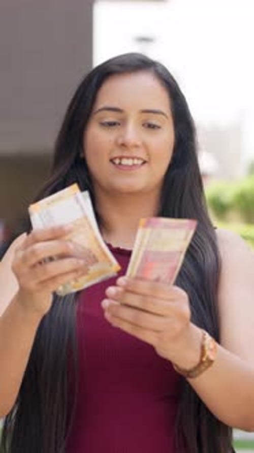 Woman Counting Currency Standing Outside