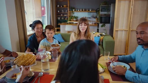 Family and Friends Eating Dinner Together at Home