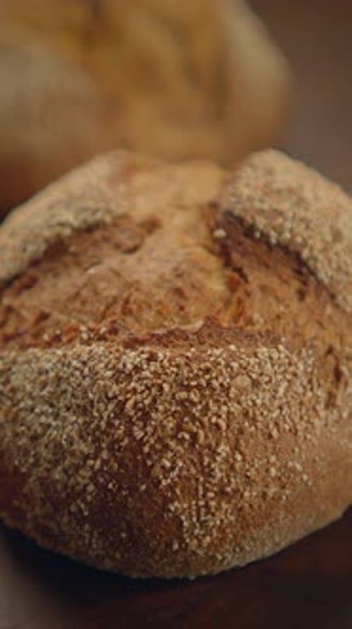 Hand Picks up Seeded Bread Roll