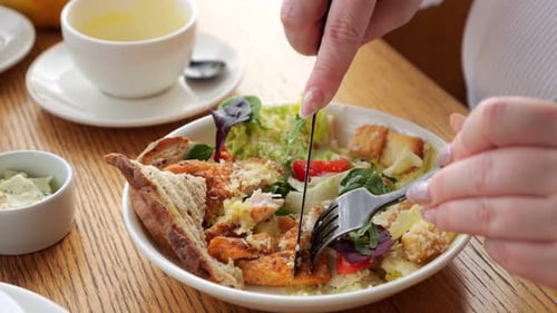 Femme mangeant une salade César avec poulet et croûtons
