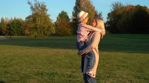 Mother Holds on Hands Happy Daughter in Autumn Park Family Walk Outdoors