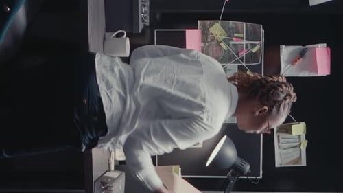 Investigator Works at Desk with Detective Board