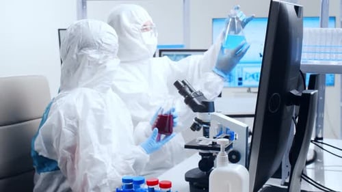 Scientists Working in Modern Lab with Liquid Samples