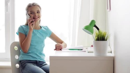 Smiling Teen Girl Talking on Phone at Desk