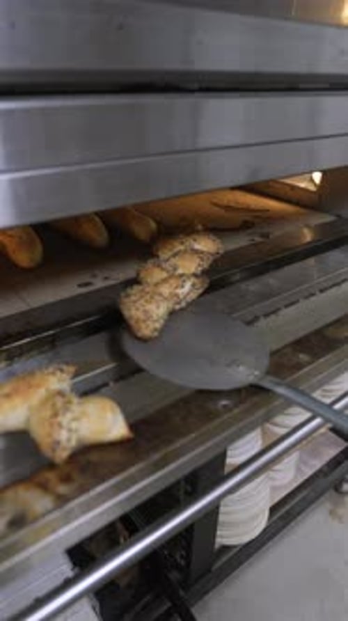 Breads removed from oven with long spatula