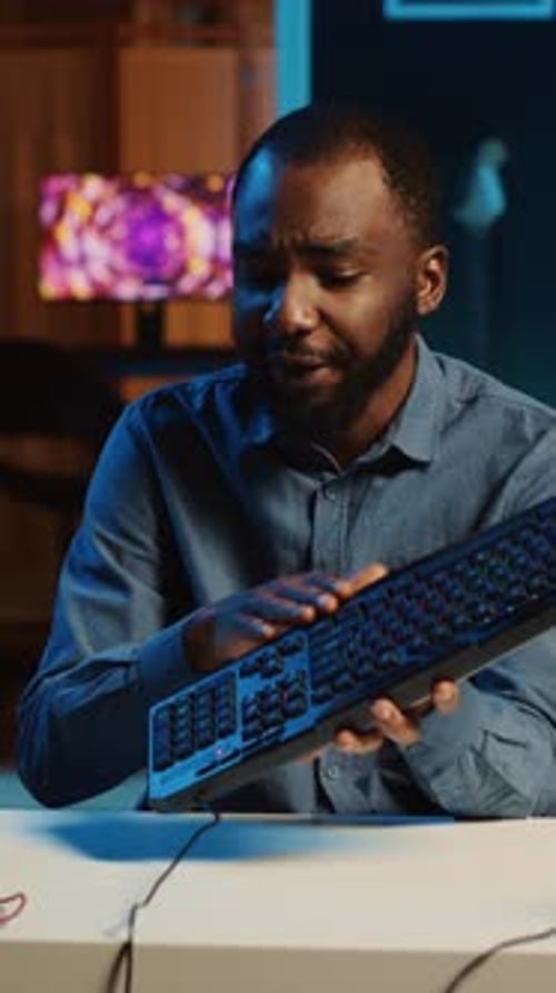 Young Adult with Keyboard Explaining Technology at Desk