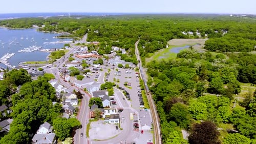 Luftbild eines Zuges, der an einem strahlend sonnigen Tag auf der Strecke durch die geschäftige Stadt fährt. Kippe nach oben.
