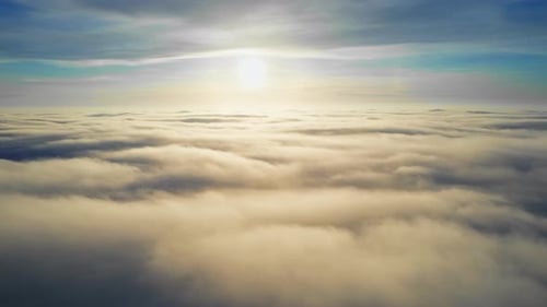 Aerial view from a drone flying above the lush clouds, bright Sun