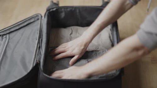 Clothes Being Packed Neatly in a Suitcase