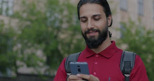 Bearded Man Using Smartphone in City Park