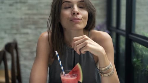 Happy, Young Woman Drinking Cocktail Sitting in Cafe 30s
