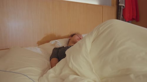 Woman Waking and Stretching in Cozy Bed