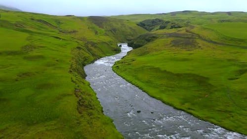 River Flows Through Verdant Valley Aerial View