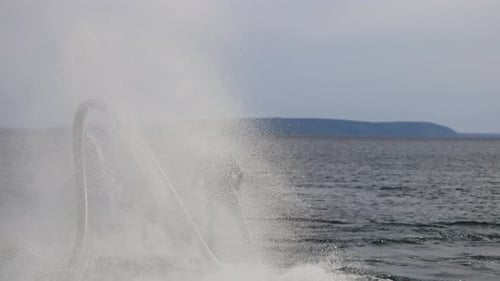El flyboard es un nuevo deporte extremo en el que un alegre flyboarder masculino vuela sobre el agua y actúa