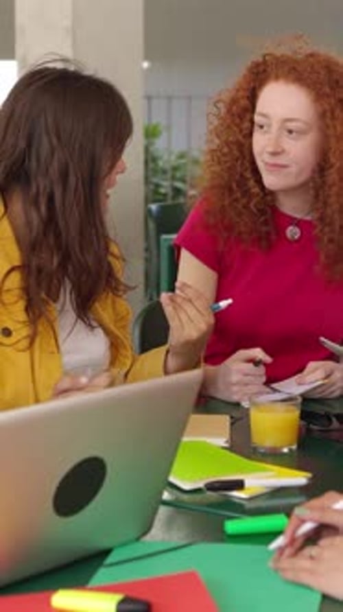 Estudantes universitários multirraciais preparando exames sentados juntos na cafeteria