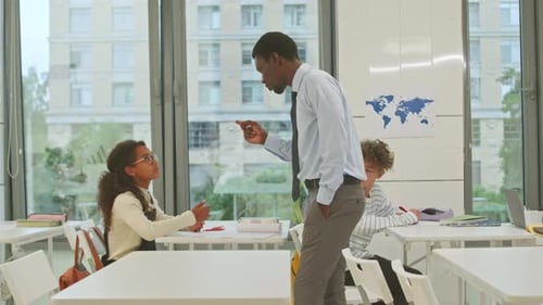 Teacher Explaining Lesson to Student in Classroom