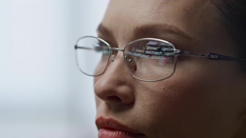 Woman Concentrating, Code Reflected in Glasses