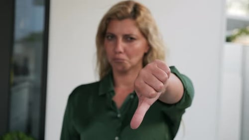 Woman Expressing Dislike with Thumbs Down Gesture