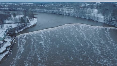 Aerial establishing view of Venta river rapids (Ventas rumba) during winter flood, old red brick bri