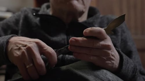 Elderly Male Master Works in His Workshop Restoring Furniture