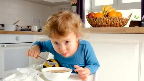 A criança come a sopa do prato