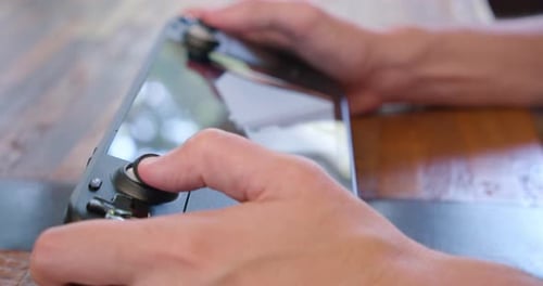 Close up playing a video game on a Steam Deck handheld game system. Soft focus shallow depth of fie