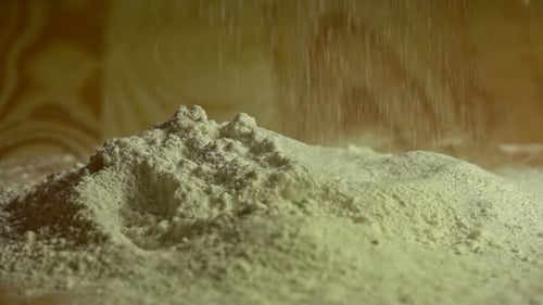 fallendes Weißmehl auf einem Holzschneidebrett
