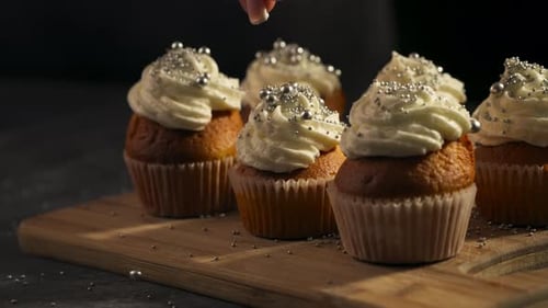 Cupcakes with Frosting and Silver Sprinkles on Wood