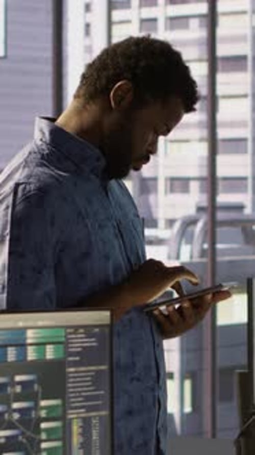 Vertikaler Videomann läuft mit Tablet im Büro und behebt Codierungsprobleme