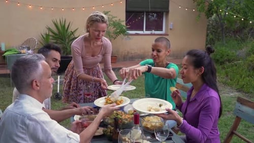 Woman Serves the Food at House Patio