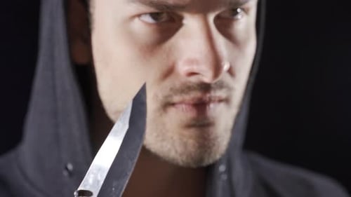 Aggressive psycho man makes dangerous move with knife.
