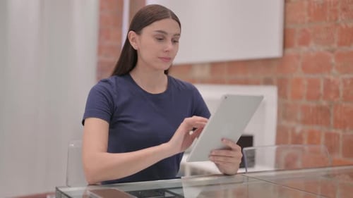 Woman Using Tablet Device at Table Indoors
