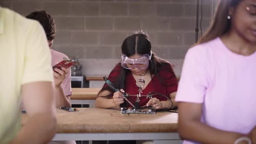 Pairs of Young Students From a Higher Vocational School in the Classroom Practicing Soldering