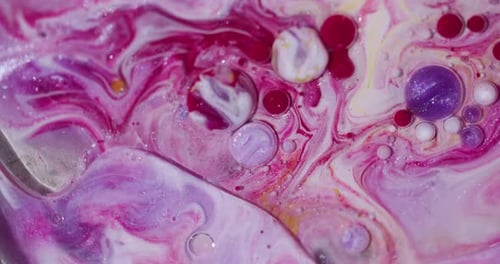 Swirling vibrant pink, white, purple, and red liquid