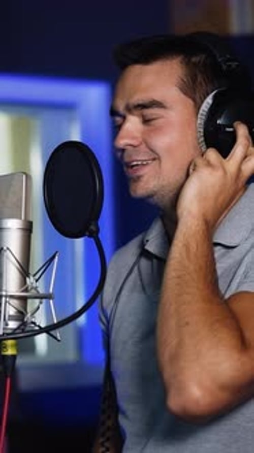 Male singer performing his song emotionally in studio.