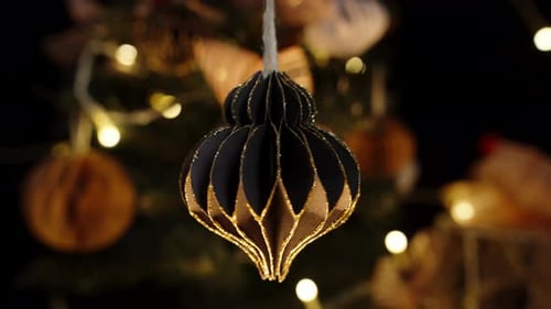Christmas Ornament Hanging from a Decorated Tree