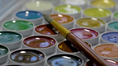 Hand Picks Paint on Brush From Watercolor Set