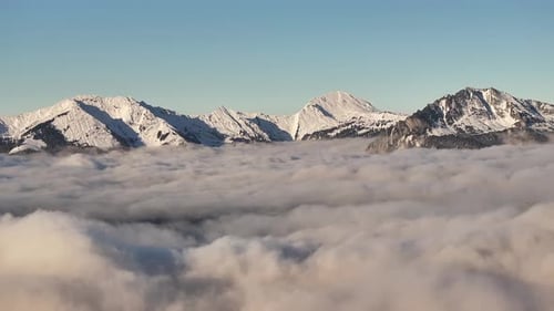 Vue aérienne époustouflante de sommets enneigés perçant une vaste mer de brouillard à Glaris Nord.