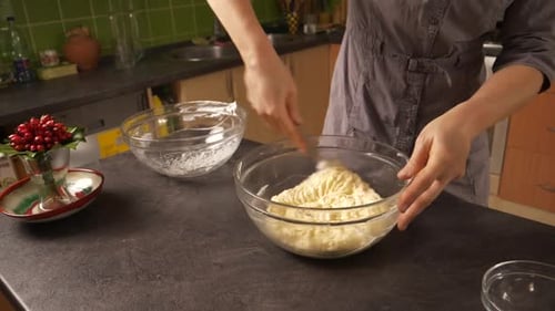 Slow zoom-in close up shot of a young woman mixing the egg white foam into the mixture of butter and
