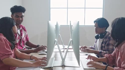 Estudantes universitários asiáticos trabalhando juntos em computadores