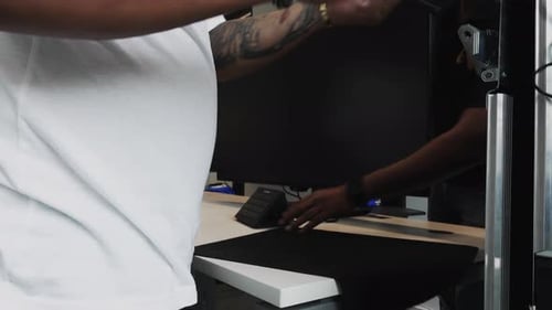 Software engineers arranging desktop and placing down a computer keyboard