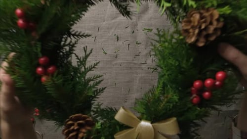 Festive Hands Arranging Christmas Pine Needle Wreath