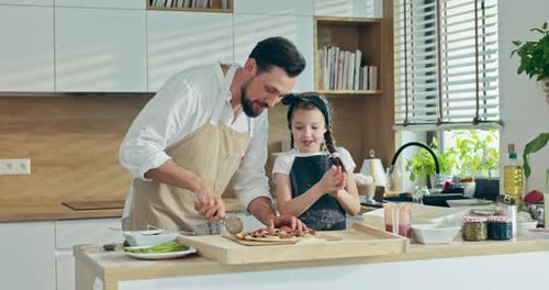 Father and Child Making Pizza Together in Kitchen