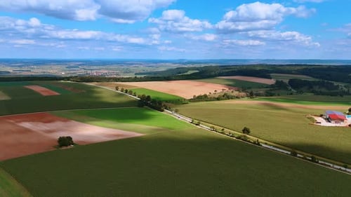 Rolling fields under bright summer sky. Aerial view of wide fields with shifting